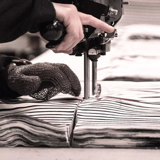 Cutting striped fabric layers with an industrial sewing machine and protective glove