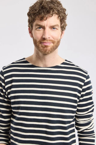 Man in navy and white striped long-sleeve shirt, casual style, against plain background