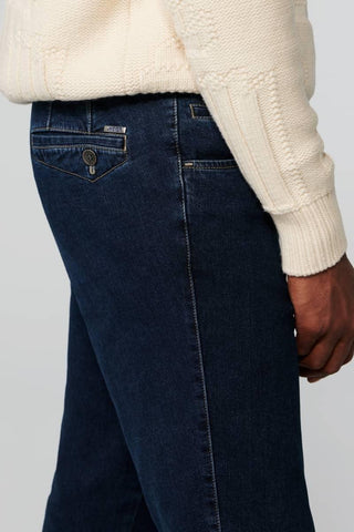 Close-up of men's dark blue Meyer jeans back pocket, worn with a cream knit sweater