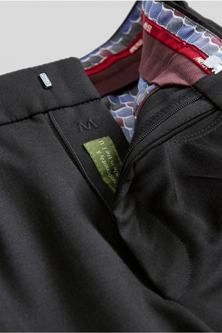 Close-up of black men's dress pants waistband with colorful patterned lining and zipper