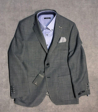 Grey wool men's blazer with light blue dress shirt and pocket square on gray background
