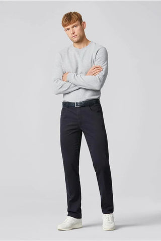 Man modeling navy cotton Meyer pants with belt, light grey sweater, and white sneakers