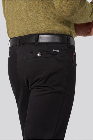 Close-up of black cotton Meyer trousers with back pocket and black belt, worn with green sweater