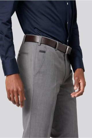 Man wearing light grey wool dress pants with brown belt and navy dress shirt