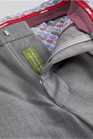 Close-up of light grey wool pants with zipper, patterned waistband lining, and interior label.