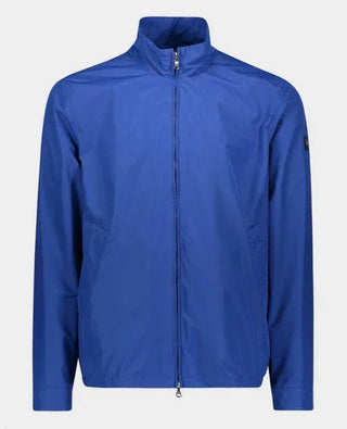Men's blue nylon zip-up jacket with high collar, long sleeves, and logo patch on sleeve