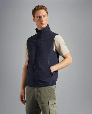 Man wearing navy nylon sleeveless vest with front zipper pockets and high collar