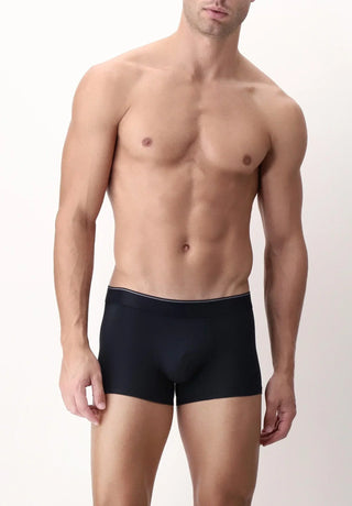 Man modeling black boxer briefs, short push-up style, against plain light background