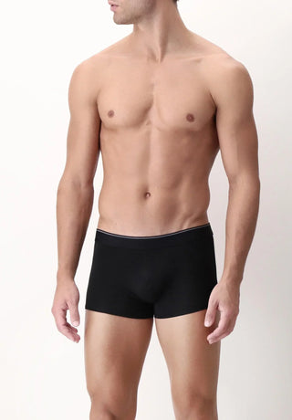 Man wearing black fitted boxer briefs on plain background