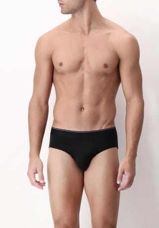 Male model wearing black men's briefs underwear against a plain background